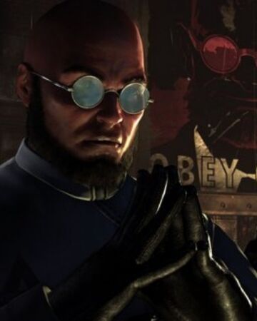 Hugo steeples his fingers in front of his own propaganda poster, with the message OBEY.